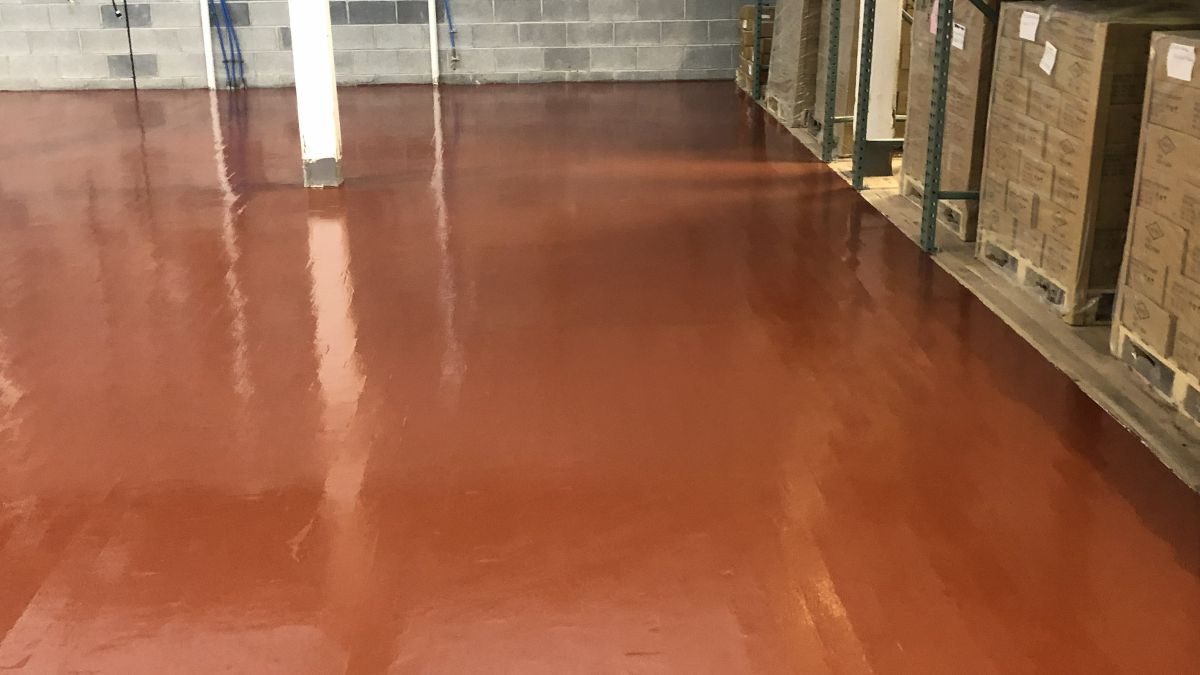Industrial installation of epoxy floors on wood subfloor in a commercial facility.