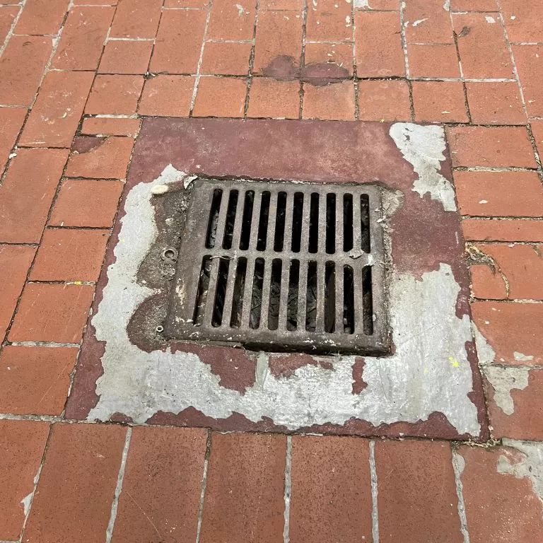 Before photo of a failing commercial kitchen floor drain area requiring professional industrial flooring repair.