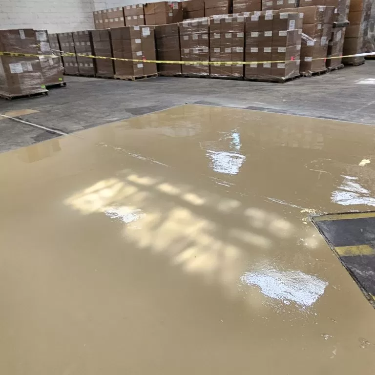 Industrial installation of a moisture vapor barrier to prevent hydrostatic pressure and floor delamination in a New Jersey warehouse.