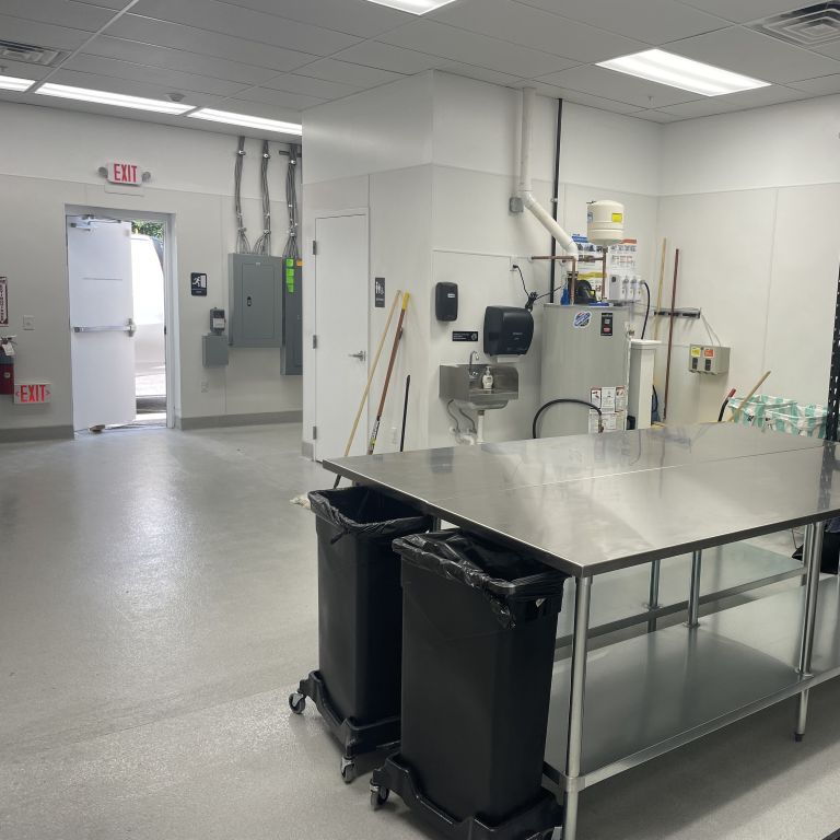 Industrial epoxy flooring in a Hoboken NJ restaurant kitchen featuring seamless finish and stainless steel equipment.