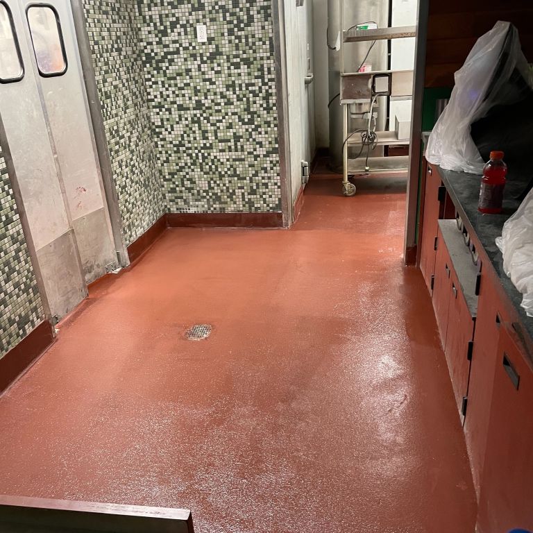 Seamless red urethane cement flooring for a commercial kitchen in Hoboken, NJ providing high-temperature and slip resistance.