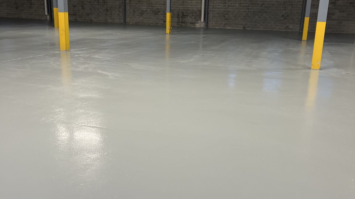 Industrial epoxy flooring installation in a North Jersey warehouse, featuring a high-gloss, durable finish for heavy forklift traffic.