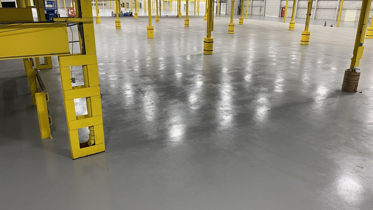 Industrial warehouse epoxy flooring installation in Central Jersey featuring a high-gloss, seamless finish and safety line striping layout.
