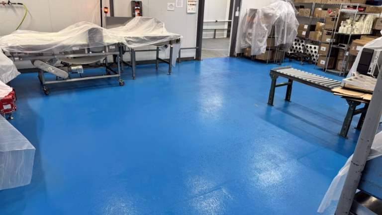 Heavy-duty red urethane cement flooring meeting USDA Compliant Commercial Kitchen Flooring around stainless steel equipment mounts in a food zone.